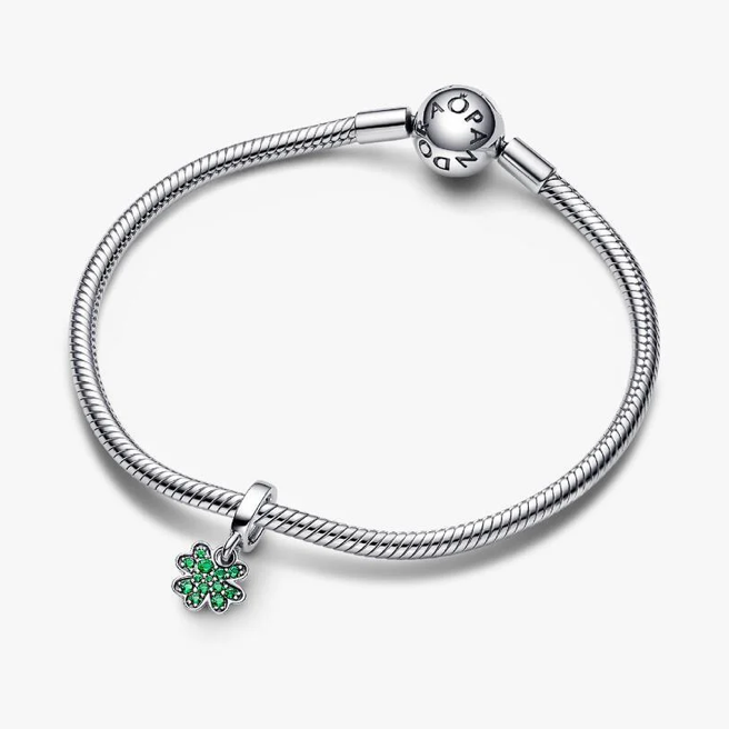 Silver bracelet with a green heart charm on a white background