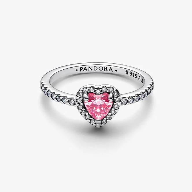 A silver Pandora ring featuring a heart-shaped pink gemstone in a halo setting, with small clear stones along the band. The inside of the band is engraved with 'PANDORA S 925 AU'.