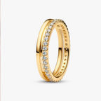 A gold eternity-style ring with a row of clear stones on one side, shown on a clean light gray background.
