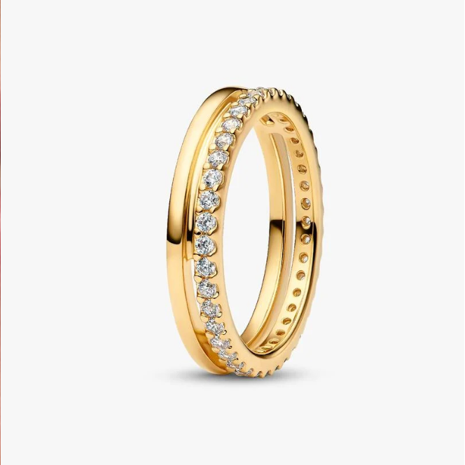 A gold eternity-style ring with a row of clear stones on one side, shown on a clean light gray background.