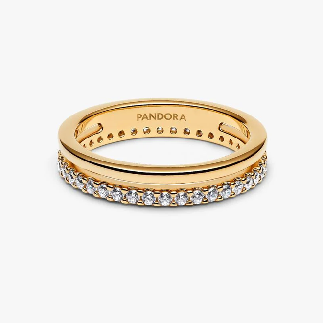 A gold Pandora ring with a row of clear pavé stones on the front band, shown on a clean white background. The inside of the band is engraved with the brand name 'PANDORA'.