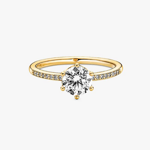 A yellow gold solitaire engagement ring featuring a round brilliant-cut clear center stone and a pavé-set band with small accent diamonds, shown on a light gray background.
