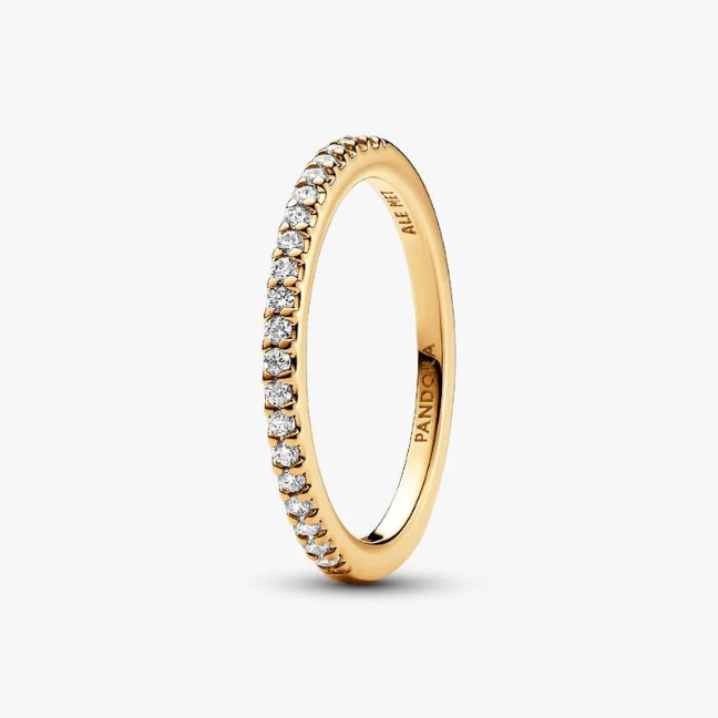 A gold eternity ring featuring a continuous row of small clear pavé-set stones, shown on a clean light gray background. The brand name 'PANDORA' is engraved inside the band.