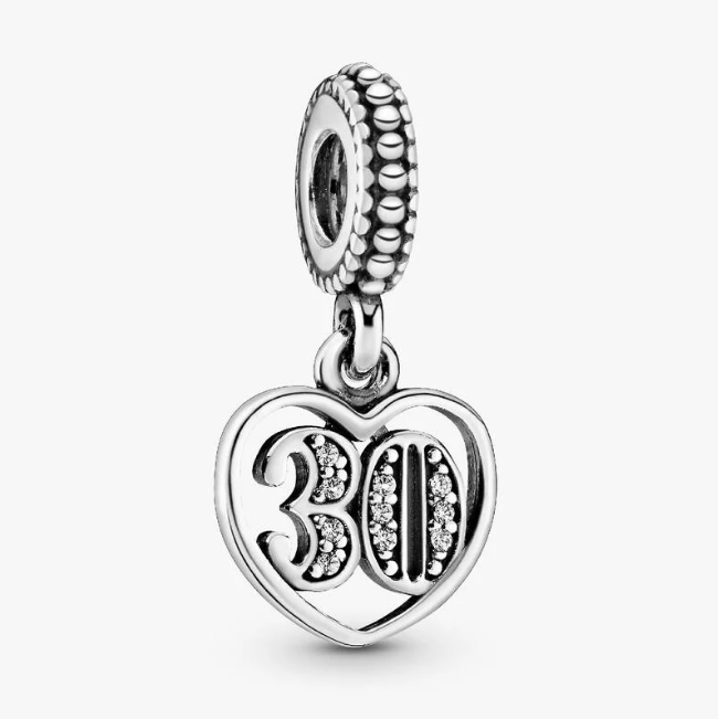 A silver 30th birthday charm featuring a heart-shaped pendant with the number 30 embellished with small clear crystals, suspended from a textured beaded top loop, shown on a light gray background.