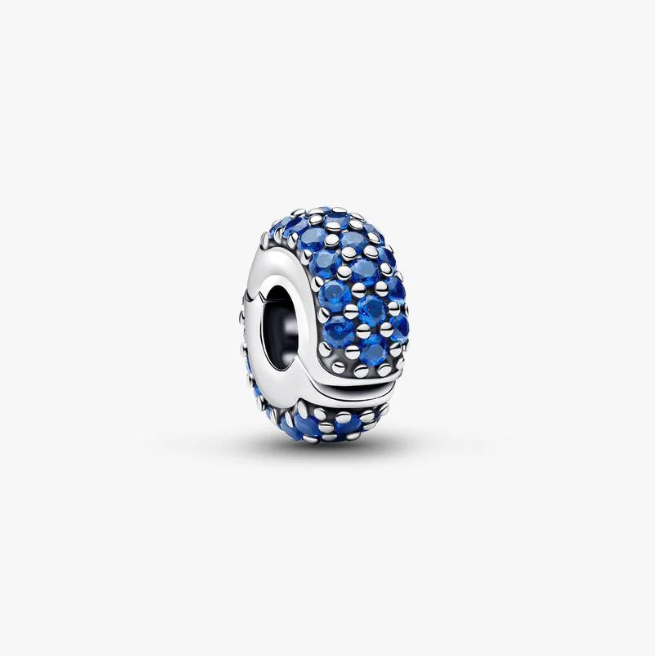 A silver charm bead featuring a textured oval face paved with deep blue rhinestones, shown on a clean white background.