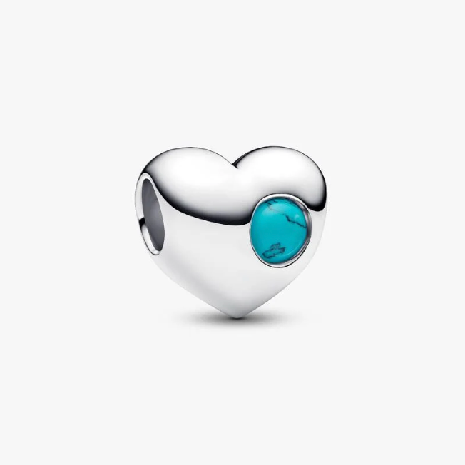 A sterling silver heart-shaped charm bead featuring a round turquoise cabochon inlay, shown on a clean light gray background.