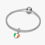 A silver-toned snake chain bracelet with a heart-shaped charm featuring the green, white, and orange colors of the Irish flag, displayed on a light gray background.