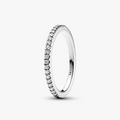 A silver eternity ring with a row of small clear stones, shown on a clean white background. The brand name 'PANDORA' is engraved inside the band.